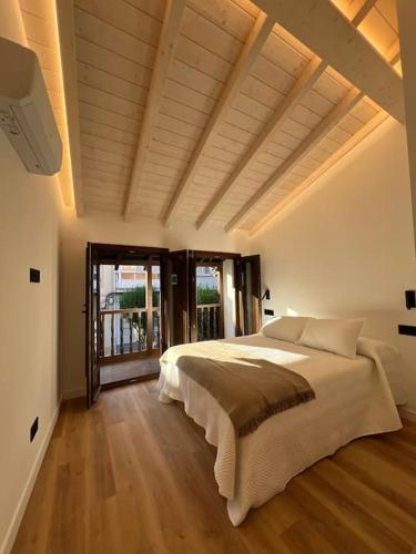 a bedroom with a large bed and a large window at Carud Nº15 in Monforte de Lemos