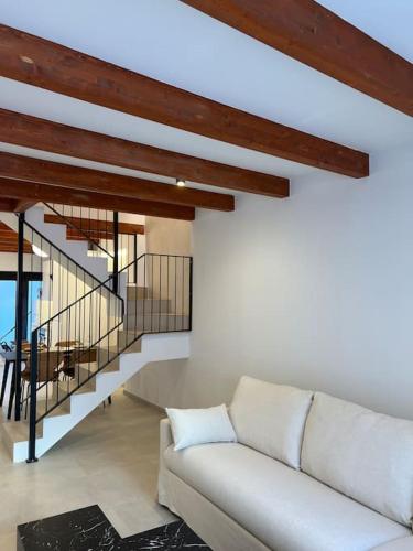 a living room with a white couch and a staircase at Carud Nº15 in Monforte de Lemos