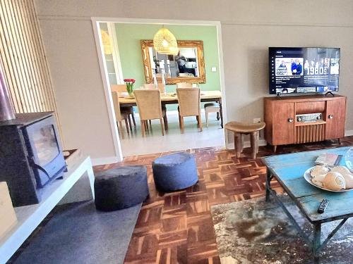 a living room with a fireplace and a dining room at Kruger Huisie Parys in Parys