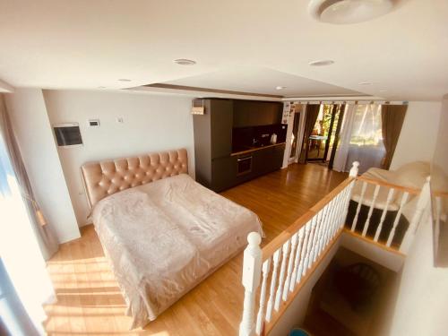 a living room with a bed and a staircase at Poilsis Nidoje -LA ISLA DE NIDA- Su terasa in Nida