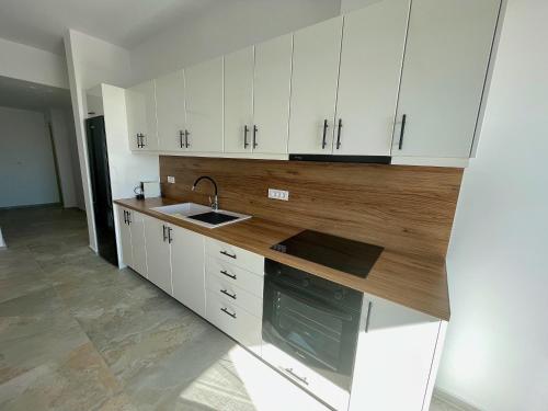an empty kitchen with white cabinets and a sink at Casa Suites Mykonos in Agios Stefanos