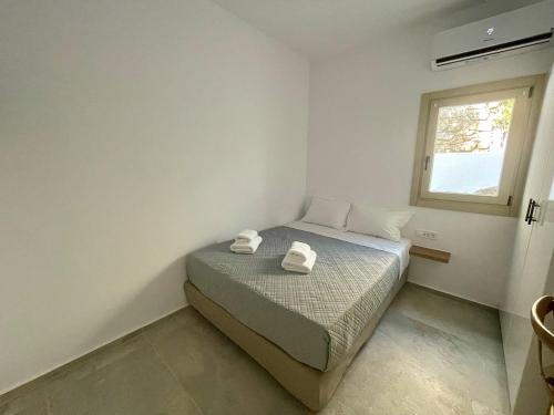 a bedroom with a bed with two towels on it at Casa Suites Mykonos in Agios Stefanos