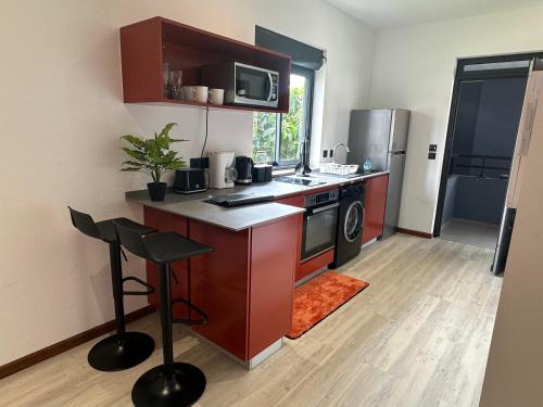 a small kitchen with a stove and a microwave at Logement avec piscine a 50 metre de la mer in Cayenne