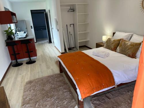 a bedroom with a large bed and a desk with a night stand at Logement avec piscine a 50 metre de la mer in Cayenne