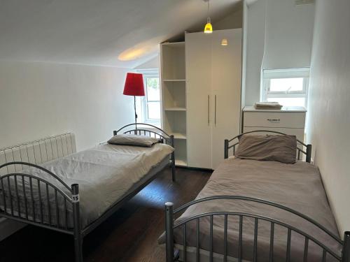 a bedroom with two beds and a red lamp at Sarsfields Communities in Dolphinʼs Barn