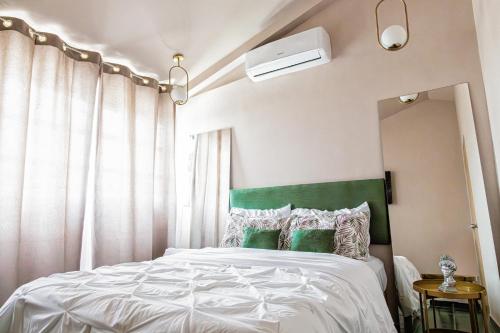 a bedroom with a bed with a green headboard at Casa Palma 2 in La Paz