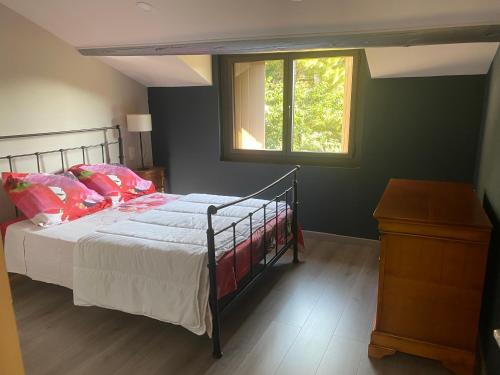 a bedroom with a bed with pink pillows and a window at Les baux in Les Baux-de-Provence