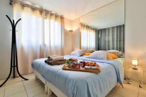 - une chambre avec un lit et un plateau de nourriture dans l'établissement 2 pièces, piscine et parking centre de St Tropez, à Saint-Tropez