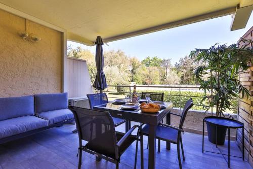 un salon avec une table, des chaises et un canapé dans l'établissement 2 pièces, piscine et parking centre de St Tropez, à Saint-Tropez