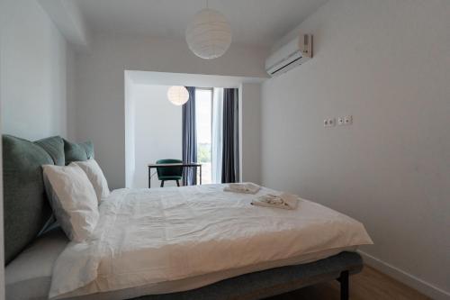 una camera da letto con un letto, una sedia e una finestra di Lagoon Park Apartments with Beach View a Bucarest