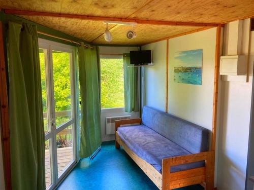 ein Zimmer mit einer Bank in einem Zimmer mit Fenstern in der Unterkunft Village de gites Stereden in Pleumeur-Bodou