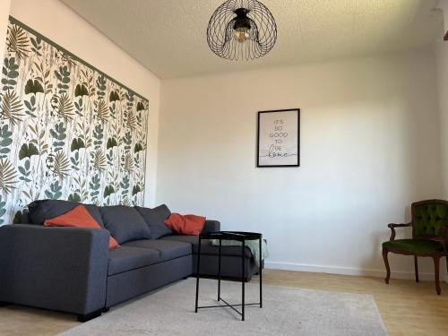 a living room with a blue couch and a chair at La Terasse des Vignes - Maison 2 Chambres - 4 Personnes in Blienschwiller