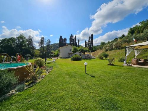 Un patio con piscina y una casa. en Raggio di sole, oasi di felicità, en Monsagrati