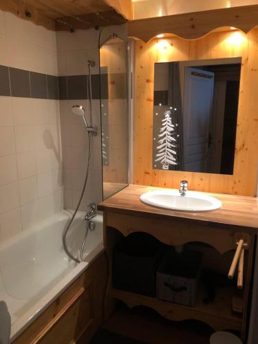 une salle de bain avec un lavabo, une baignoire et un miroir dans l'établissement Appartements Ski Spa & Confort Orelle-3 vallées, à Orelle