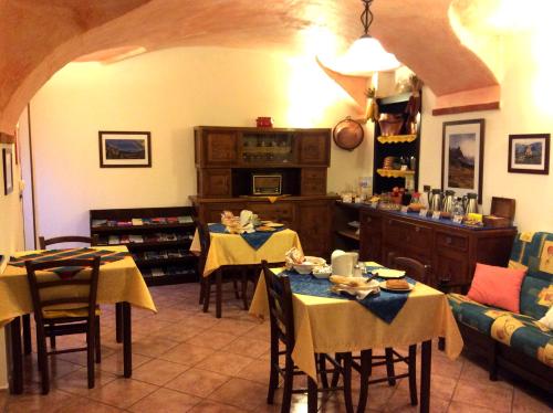a living room with tables and chairs and a kitchen at L'Antico Borgo Rooms Rental in Caprie