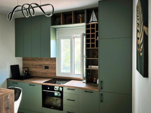 a kitchen with green cabinets and a window at Sea Level in Kotor