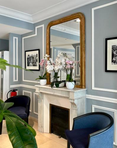 - un salon avec un miroir et une cheminée dans l'établissement Hôtel Central Saint Germain, à Paris