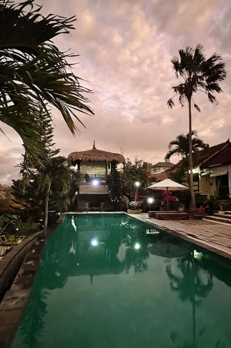a swimming pool with a gazebo in the background at Villa Anjing in Nusa Dua