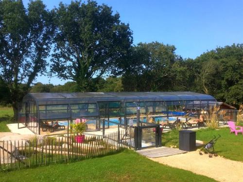 un grand bâtiment avec une piscine dans un parc dans l'établissement Village de gites Stereden, à Pleumeur-Bodou