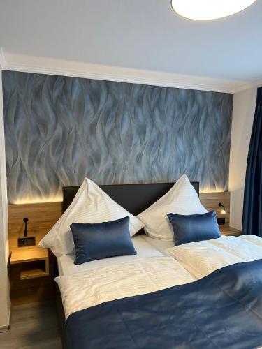 a bedroom with two beds with blue and white pillows at Hotel Restaurant Wolfsschlucht GmbH in Bad Münstereifel