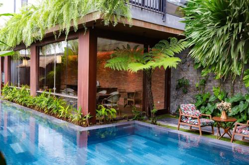 a house with a swimming pool in front of a building at K House Apartment Danang Beach in Da Nang