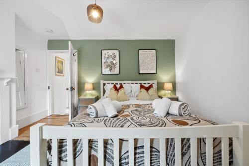 a bedroom with a large bed with green walls at 2-Bedroom Stylish & Gorgeous, Cosy Westgate Cottage Retreat, Central Winchester, Free On-Street Parking Permit, with Garden, Close to Cathedral - Sleeps 6, Pets are Welcome - by Blue Puffin Stays in Winchester