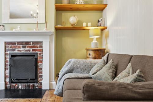 a living room with a couch and a fireplace at 2-Bedroom Stylish & Gorgeous, Cosy Westgate Cottage Retreat, Central Winchester, Free On-Street Parking Permit, with Garden, Close to Cathedral - Sleeps 6, Pets are Welcome - by Blue Puffin Stays in Winchester