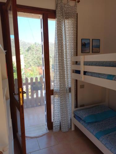 a bedroom with two bunk beds and a balcony at Casetta Anna y nietos in Solanas