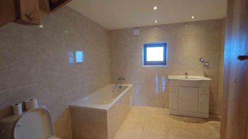 une salle de bain avec une baignoire et un lavabo dans l'établissement Atypique maison de charme, à Parisot