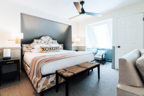 a bedroom with a large bed and a chair at Mercury Hotel Provincetown in Provincetown