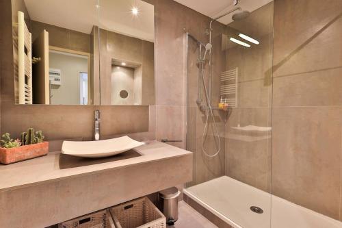 une salle de bain avec un lavabo et une douche dans l'établissement Centre St Tropez - Gd 2 pièces, piscine et parking, à Saint-Tropez