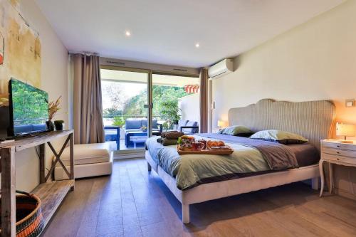 - une chambre avec un lit et un plateau de nourriture dans l'établissement Centre St Tropez - Gd 2 pièces, piscine et parking, à Saint-Tropez