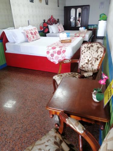 a bedroom with a bed and a table and chairs at Sang Yoo Mountain View Tagaytay Bed and Breakfast - Taal Lake View in Tagaytay
