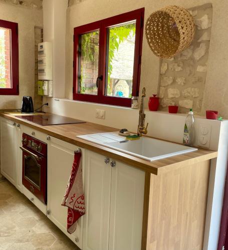 a kitchen with a sink and a counter top at Maison chaleureuse- cheminée, nature et sport ! in Muids