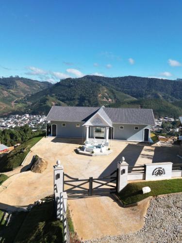 a house on top of a hill with mountains in the background at Pousada & Hotel Fazenda Segredo Das Águas in Alto Caparao