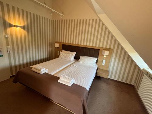 a bedroom with a bed with white sheets and pillows at Hotel Ortel GmbH in Besigheim