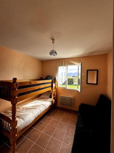 une chambre avec un lit superposé et une fenêtre dans l'établissement Charmante Maison de Montagne, à Benqué