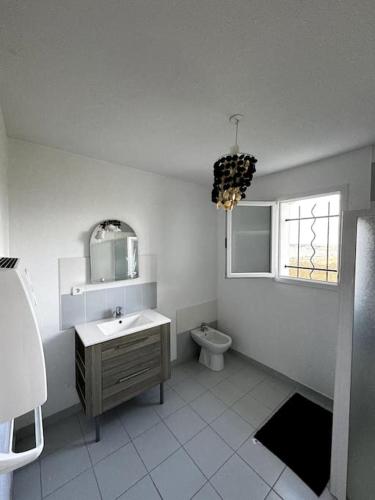 une salle de bain avec toilettes, lavabo et fenêtre dans l'établissement Charmante Maison de Montagne, à Benqué