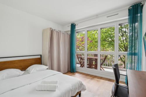 a bedroom with a bed and a table and a window at Duplex apartment downtown with parking in Cergy