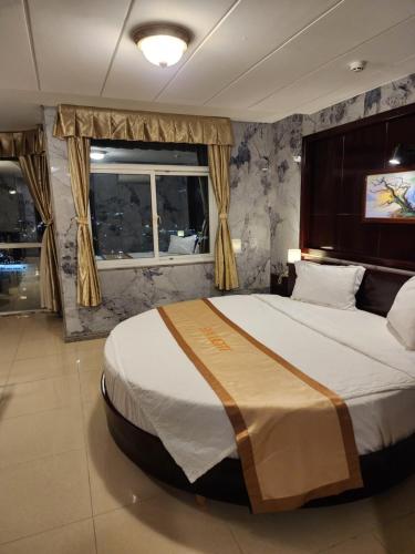 a bedroom with a large bed and a window at Sea Light Hotel in Rach Gia