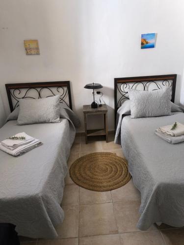 a bedroom with two beds and a table with a lamp at Casas Rurales Villa Sargento in Níjar