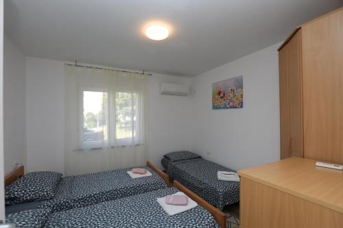 a small room with two beds and a desk at Apartment Ondina in Rijeka