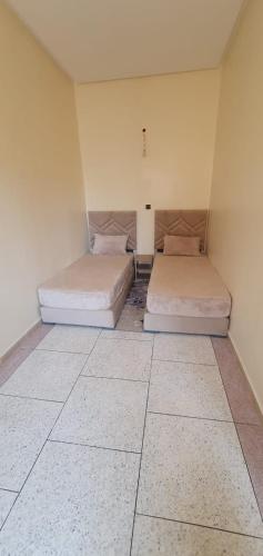 two beds sitting in a room with a room with two at hôtel mamounia el hajeb in El Hajeb