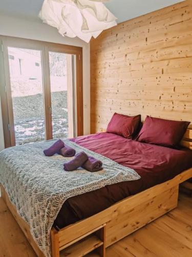 - une chambre dotée d'un lit avec des chaussures violettes dans l'établissement Bel appartement 3 pièces, 62 m2, 2 à 6 personnes, très calme, aux Gets