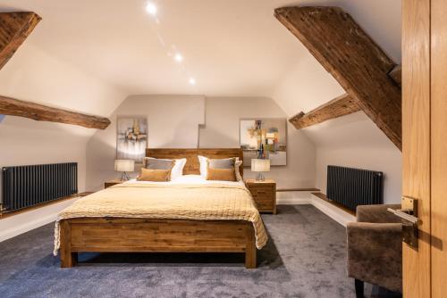 a bedroom with a large bed and a chair at The Loft at Goytre Hall in Abergavenny