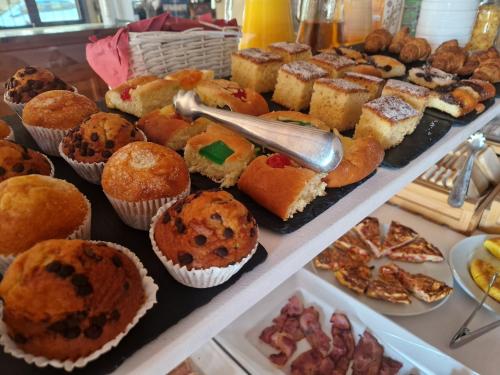 a bunch of muffins and other pastries on a shelf at Hotel Bodegón de Peñíscola in Peñíscola