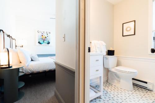 a bathroom with a toilet and a bed at Mercury Hotel Provincetown in Provincetown