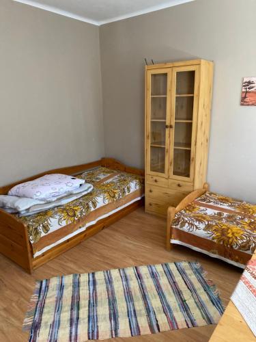 a room with two beds and a cabinet at Pokoje przy Tamie in Włocławek