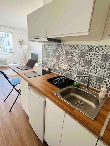 une cuisine avec un évier et un ordinateur portable sur un comptoir dans l'établissement Massilia Mood ,Centre, Stade vélodrome, La Timone, La conception , WIFI GRATUITE, à Marseille
