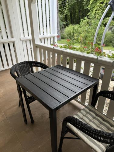 a black wooden table and chairs on a porch at Szem-s Vendégház in Balatonszemes